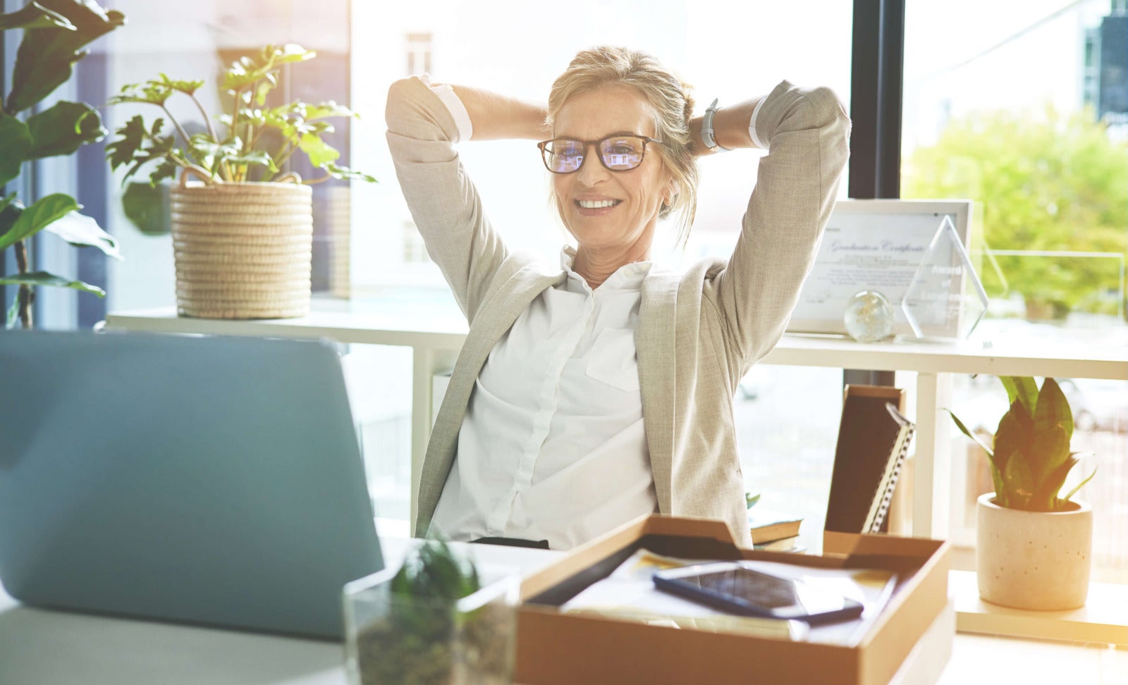 business leader sits at desk looking satisfied with work