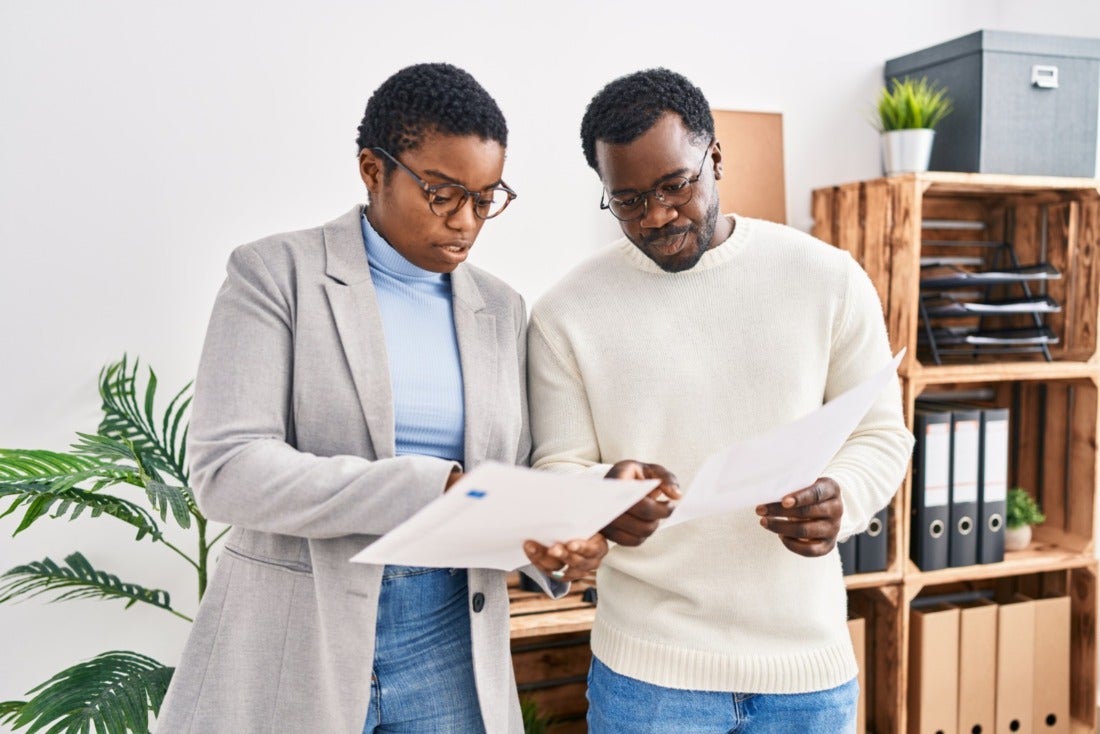 Two hiring managers reviewing legal paperwork