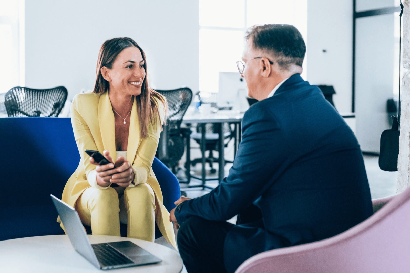 senior business leader discusses work with employee at office lounge area